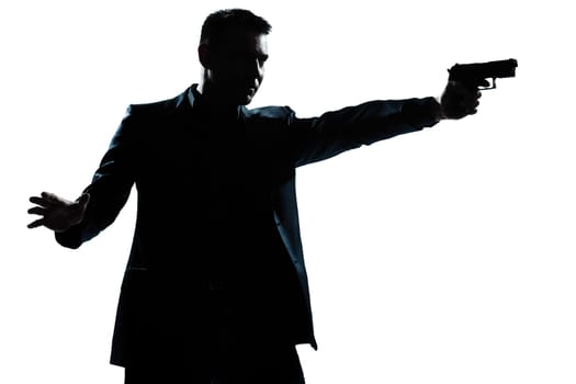 one caucasian man with gun aiming portrait silhouette in studio isolated white background