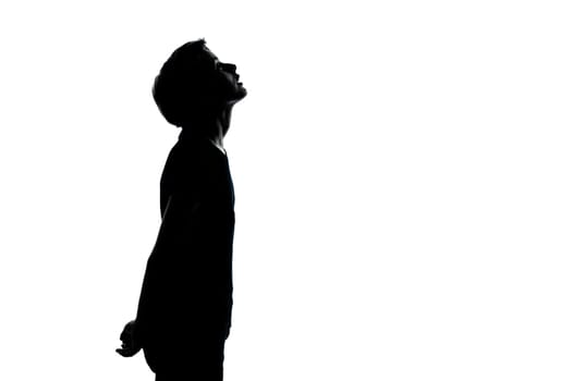 one caucasian young teenager silhouette boy or girl looking up portrait in studio cut out isolated on white background