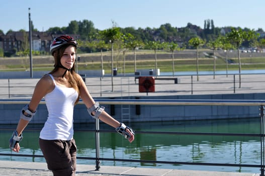 Young woman driving at a lake with inline skates