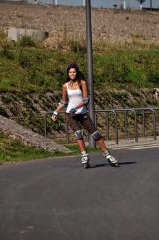 Woman having fun riding rollerblades outdoors in summer
