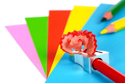 Several sheets of colored paper,pens and a colored pencil that is sharpened