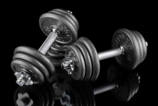 Two heavy dumbbells on a black background