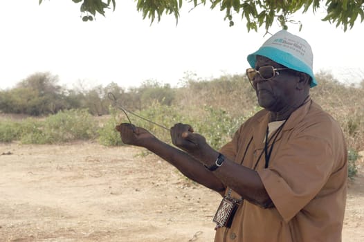African waterfinder with work in an area of Burkina Faso Faso. Water is not rare in Africa, only it is necessary to drill wells to reach it. The waterfinder thus determines the place exact where to drill because drilling costs 8000 ? and it is not questio