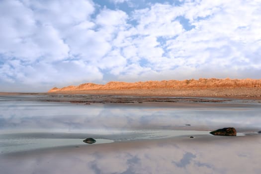 golden sand dunes on an irish beach reflected on deserted beach