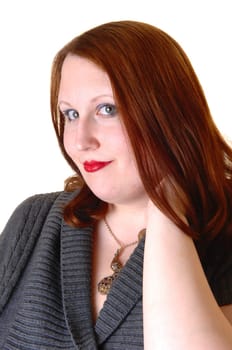 A very pretty young woman in a portrait shot, wearing a gray dress and red brunette hair, looking into the camera for white background.