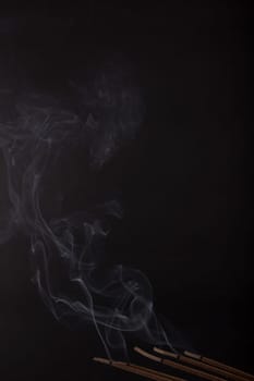 Burning incense on the black background