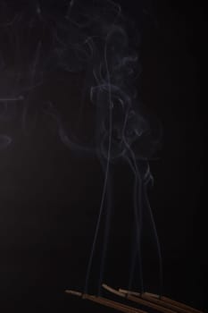 Burning incense on the black background