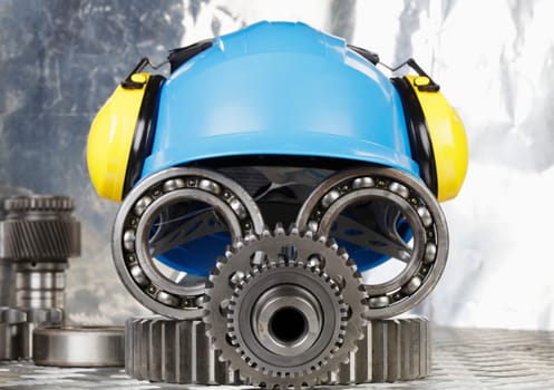 hardhat with earmuffs, gears and bearings, conceptual image of industrial face