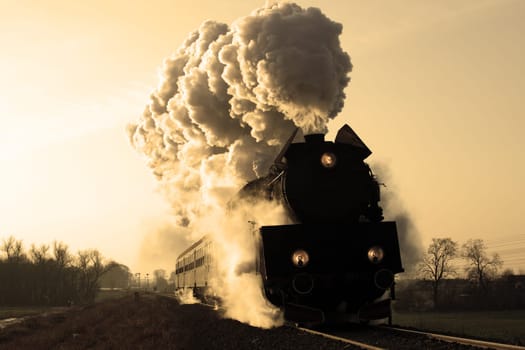 Vintage steam train starting from the station, wintertime