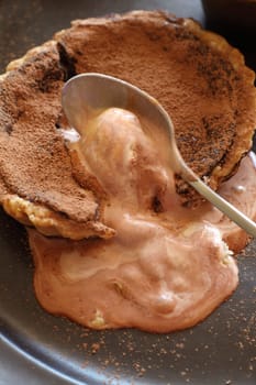 Beautiful fresh baked chocolate tart with melted caramel ice cream.