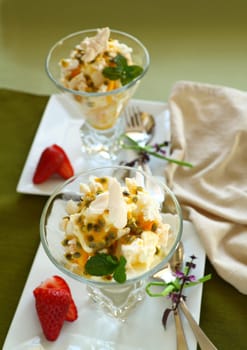 Delicious meringue dessert with pawpaw and passionfruit sauce with strawberries.