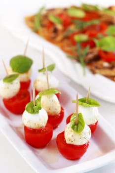 Delicious appetizer - mozzarella cheese with tomato and champignon carpaccio