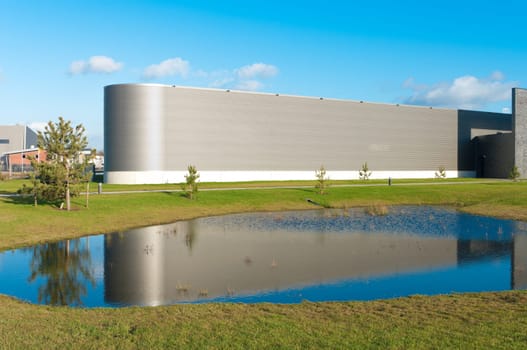 modern shiny industrial building reflected in a small pond