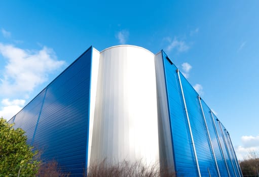 modern white with blue industrial building against a blue sky