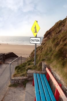 bench and a landslide sign in ballybunion county kerry ireland on a beach path