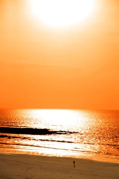 sunshine reflected on a golden beach with jogger of the west coast of ireland