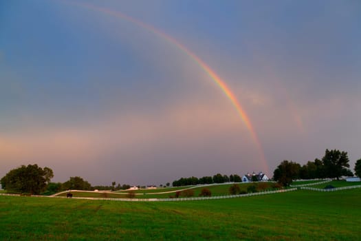 Scenic view of a horse farm after storm with double rainbow