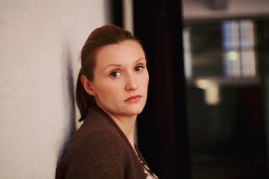 Portrait of a beautiful woman, looking serious. Natural portrait indoors.