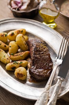 Fresh beef steak with baked potatoes close up shoot