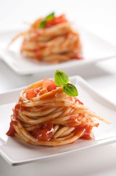 Spaghetti with tomato sauce and basil close up
