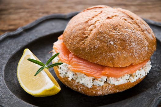 Fresh salmon sandwich with lemon close up