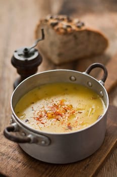 Fresh pumpkin soup on wooden table close up