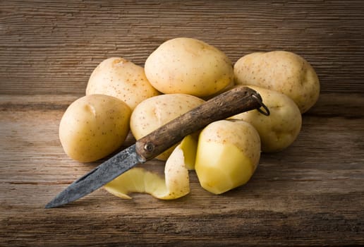 Fresh potatoes on wooden background close up