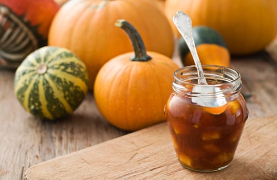 Fresh pumpkin marmalade on wooden table close up shoot