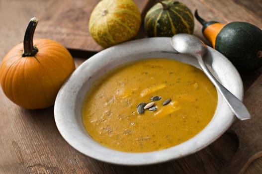 Fresh pumpkin soup on wooden table close up