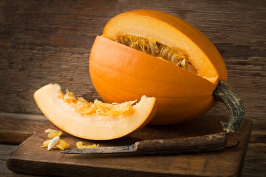 Fresh pumpkin sliced on wooden background close up