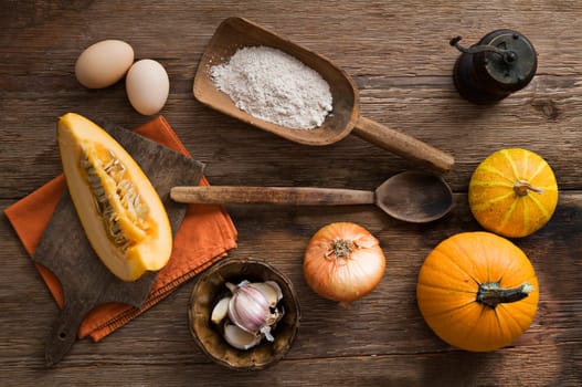 Pumpkin soup ingredients on wooden background close up