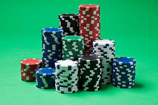 Gambling chips on green background close up