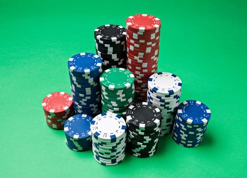 Gambling chips on green background close up