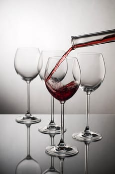 Red wine pouring into glass close up