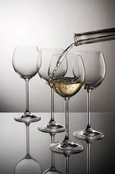 White wine pouring into glass close up