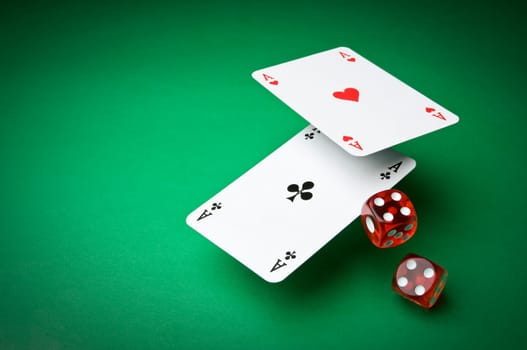 Cards and dices on green background close up