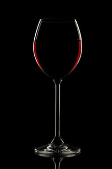 Red wine in glass on black background close up