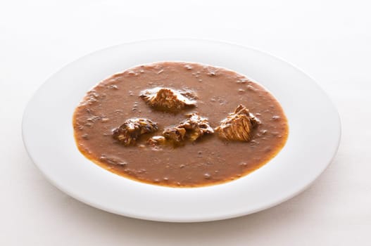 Beef goulash on white table close up shoot