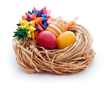 Colorful easter eggs and butarica in nest isolated on white