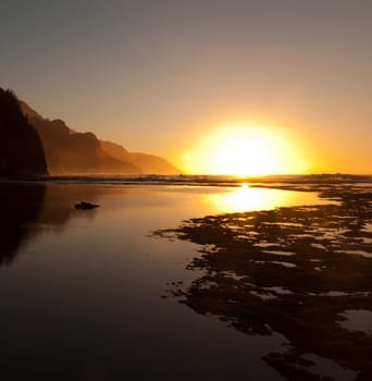 Reflections of setting sun over Na Pali coast by Ke&#039 e beach in Kauai at sunset