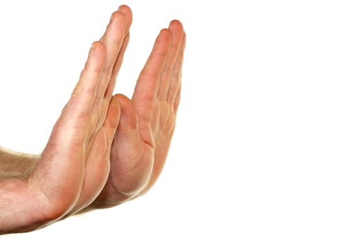Adult male hands seen from the side with palms raised up in a stop gesture in front of a white background.