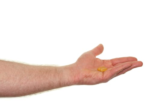 Caucasian hand showing a dose of a fish oil soft gel supplement in front of a white background.