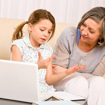 Grandmother with granddaughter use laptop learn counting together home
