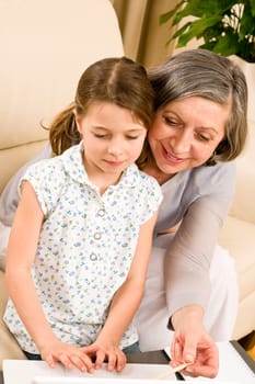 Grandmother with young girl use computer laptop happy together
