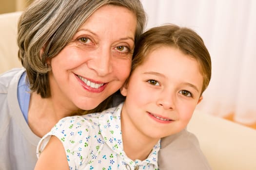 Grandmother and granddaughter hugging together smiling close-up portrait