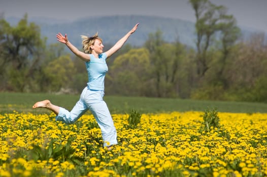 young blond happy woman running on grass