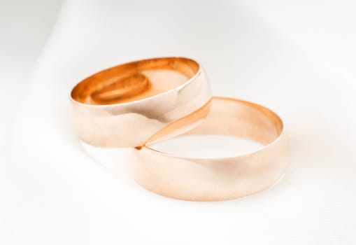 two golden rings on silk close up shoot
