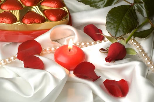 valentines day objects arranged with candle in the middle