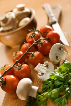 fresh tomato and mushrooms on cutting board close up