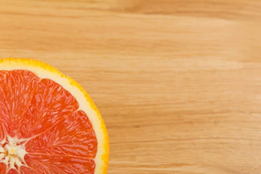 Cut orange lies on a wooden plate